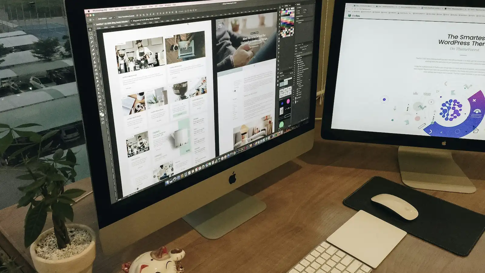 Modern web design workspace with two computer monitors and a keyboard